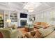 Bright living room featuring a coffered ceiling, fireplace, built-in shelving, and plantation shutters at 6002 Green Dolphin Way, Kiawah Island, SC 29455