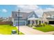 Charming home featuring a covered porch, gray siding, a well-manicured lawn, and an attached two-car garage at 627 Macintyre Cir, Summerville, SC 29486