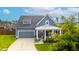 Charming home featuring a covered porch, gray siding, a well-manicured lawn, and an attached two-car garage at 627 Macintyre Cir, Summerville, SC 29486