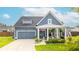 Charming home featuring a covered porch, gray siding, a well-manicured lawn, and an attached two-car garage at 627 Macintyre Cir, Summerville, SC 29486