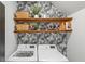 Modern laundry room features front-load washer and dryer, open shelving and patterned wallpaper at 627 Macintyre Cir, Summerville, SC 29486