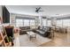 Spacious living room features hardwood floors, a dark leather sofa, modern ceiling fan and dining area at 627 Macintyre Cir, Summerville, SC 29486