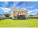 Spacious backyard featuring a lush lawn, screened-in porch, and mature landscaping, perfect for outdoor entertaining at 661 Black Pine Rd, Moncks Corner, SC 29461