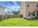 A well-maintained backyard with a wooden fence, green lawn, and view of the home's exterior features at 661 Black Pine Rd, Moncks Corner, SC 29461