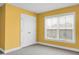 This bedroom has bright yellow walls, neutral carpet, closet, and a window at 661 Black Pine Rd, Moncks Corner, SC 29461
