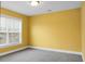 Bedroom boasts bright yellow walls, neutral carpet, natural light, and modern window blinds at 661 Black Pine Rd, Moncks Corner, SC 29461