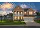 Two-story home with front porch, two-car garage, landscaped lawn, and fireworks in the background at 661 Black Pine Rd, Moncks Corner, SC 29461