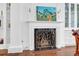 A beautifully decorated fireplace with a white mantle and decorative screen at 8 & 8 1/2 Elliott St # 8 & 8 1/2, Charleston, SC 29401