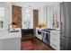 Bright kitchen with stainless steel appliances, quartz countertop, wood floors and exposed brick accent wall at 8 & 8 1/2 Elliott St # 8 & 8 1/2, Charleston, SC 29401