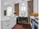 Stylish kitchen with white countertops, exposed brick wall, and rustic rug at 8 & 8 1/2 Elliott St # 8 & 8 1/2, Charleston, SC 29401