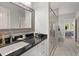 Bathroom features granite countertops, decorative framed mirrors, and an open doorway to the Primary bedroom at 8605 Refuge Point Cir, North Charleston, SC 29420