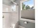 Bathroom featuring a bathtub-shower combination with clear glass doors and a window at 8605 Refuge Point Cir, North Charleston, SC 29420
