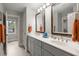 Bathroom featuring double sinks, decorative mirrors, and a doorway leading to another bathroom at 8605 Refuge Point Cir, North Charleston, SC 29420