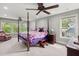 Well-lit bedroom features a four-poster bed, ceiling fan, and large windows offering natural light and views at 8605 Refuge Point Cir, North Charleston, SC 29420