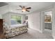 Comfortable bedroom with a ceiling fan and large windows that provide ample natural light and outside views at 8605 Refuge Point Cir, North Charleston, SC 29420