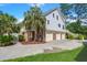 Gorgeous home exterior with a three-car garage, stairway to a deck, and mature palm trees at 8605 Refuge Point Cir, North Charleston, SC 29420