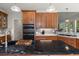 Kitchen island features dark countertops, wooden cabinets, built-in oven, and stainless steel appliances at 8605 Refuge Point Cir, North Charleston, SC 29420