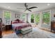 Main bedroom featuring a ceiling fan, wood floors, bright windows and a door to the balcony at 8605 Refuge Point Cir, North Charleston, SC 29420