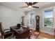 Home office with large desk, grandfather clock, and natural light from two windows at 8605 Refuge Point Cir, North Charleston, SC 29420
