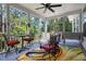 Relaxing screened porch with seating and colorful rug with a wooded backyard at 8605 Refuge Point Cir, North Charleston, SC 29420