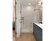 Bright bathroom featuring a shower, white tile, wooden floor, and a sink with a blue vanity at 926 Pitt St, Mount Pleasant, SC 29464