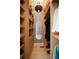 A well-organized walk-in closet with wooden shelves and drawers, decorated with wallpaper and a mirror at 926 Pitt St, Mount Pleasant, SC 29464