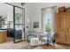 Comfortable sitting area with patterned chairs, glass-enclosed door, and view into the kitchen at 926 Pitt St, Mount Pleasant, SC 29464