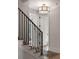 Staircase with a unique lighting fixture and a combination of wood and iron railing at 926 Pitt St, Mount Pleasant, SC 29464