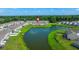 An aerial view of townhomes surrounding a scenic pond in a well-manicured community at 9712 Transplanter Cir, Ladson, SC 29456