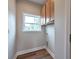 Bright laundry room featuring wooden cabinets, wood-style flooring, and a window offering natural light at St, Saint George, SC 29477