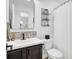 Bathroom featuring dark wood cabinets, black faucet, black framed mirror, shower curtain and wall shelving at 100 Runnels Cv, Summerville, SC 29485