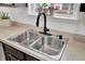 Close up of a stainless steel sink with black faucet and window with plants at 100 Runnels Cv, Summerville, SC 29485