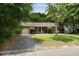 Charming brick home featuring a well-manicured lawn, mature tree, and a welcoming front porch at 1002 Sea Gull Dr, Mount Pleasant, SC 29464
