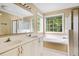 Bright bathroom featuring double vanity, garden tub with window, and separate tiled shower at 103 Retriever Ln, Goose Creek, SC 29445