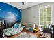 bedroom featuring a navy accent wall, hardwood floors, and a gray rocking chair at 103 Retriever Ln, Goose Creek, SC 29445