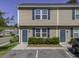 Tan townhouse exterior features blue doors, shutters and a well-maintained landscape at 1034 Lexi Ct, Ladson, SC 29456