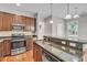Well-lit kitchen features stainless steel appliances, granite countertops, and wooden cabinets at 1034 Lexi Ct, Ladson, SC 29456