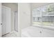 Bright bathroom with a soaking tub, glass-enclosed shower, and marble-style tile flooring at 106 Brandy Ct, Summerville, SC 29485