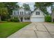 Charming two-story home with a well-manicured lawn, inviting front porch, and attached garage provides an inviting curb appeal at 106 Brandy Ct, Summerville, SC 29485