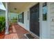 Covered front porch with brick flooring, white columns, and black front door provides a welcoming entrance to the home at 106 Brandy Ct, Summerville, SC 29485
