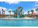 Resort-style community pool with a water slide, palm trees, lounge chairs, and umbrellas under a bright blue summer sky at 111 Medford St, Summerville, SC 29486