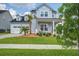 Charming two-story home with a well-manicured lawn, palm trees, a welcoming porch, and a two-car garage at 111 Medford St, Summerville, SC 29486