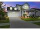 Charming two-story home with a manicured lawn, covered porch, and attached two-car garage at dusk at 111 Medford St, Summerville, SC 29486