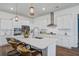 Bright kitchen featuring white cabinetry, stainless steel appliances, a large island with seating, and modern pendant lighting at 111 Medford St, Summerville, SC 29486
