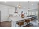 Bright kitchen featuring white cabinetry, stainless steel appliances, a large island with seating, and modern pendant lighting at 111 Medford St, Summerville, SC 29486