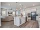 Open-concept living room featuring a kitchen island, stainless steel appliances, a plush sectional sofa, and a fireplace at 111 Medford St, Summerville, SC 29486