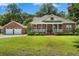 Charming brick home boasts a welcoming front porch, lush lawn, and detached two-car garage at 1119 Bruton Blvd, Moncks Corner, SC 29461