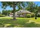 Traditional brick home with a well-manicured lawn and a detached two-car garage, surrounded by trees at 1119 Bruton Blvd, Moncks Corner, SC 29461