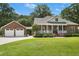 Inviting brick home with a covered front porch, detached two-car garage, and lush green lawn at 1119 Bruton Blvd, Moncks Corner, SC 29461