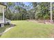 Expansive backyard with a large grassy area, trees, and a fenced animal enclosure at 119 White Picket Ln, Summerville, SC 29483